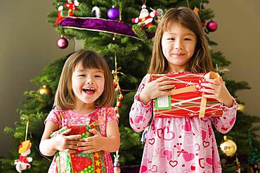 Two young sisters with Christmas presents