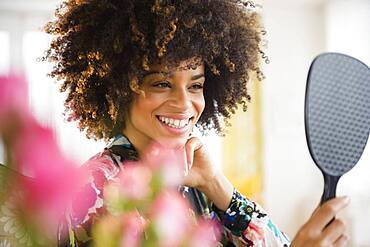 Mixed race woman admiring herself in mirror