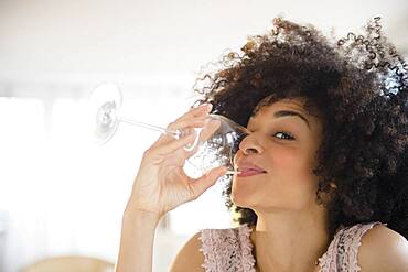 Mixed race woman drinking glass of wine