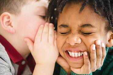 Close up of boys whispering secrets