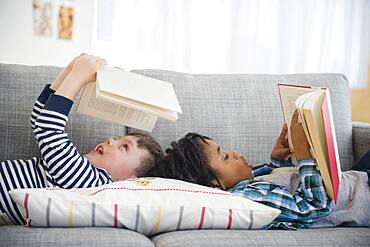 Boys reading on living room sofa