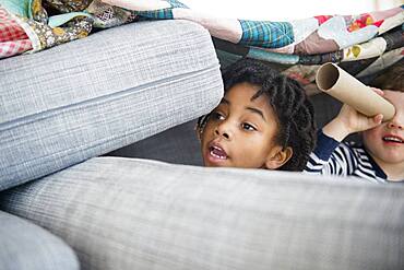 Boys playing in pillow fort