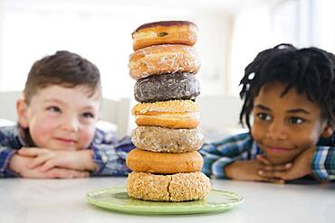 Boys admiring stack of donuts on counter