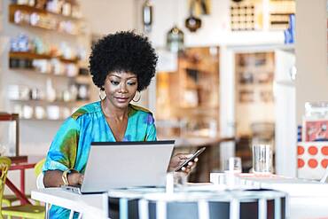 African American business owner using laptop in store