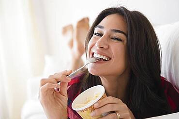 Close up of woman eating ice cream on sofa