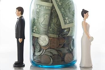 Close up of bride and groom dolls near savings jar