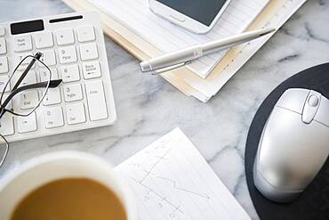 Close up of computer equipment, files and coffee on office desk