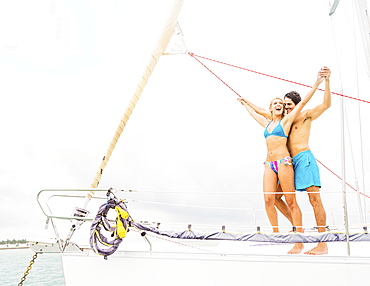 Couple standing on deck of sailboat