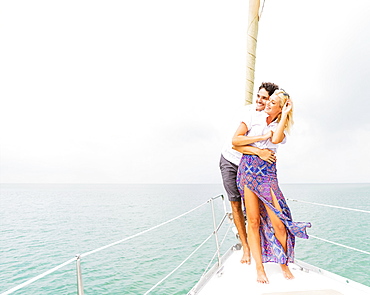 Couple hugging on deck of sailboat