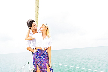 Couple hugging on deck of sailboat