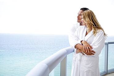 Couple hugging on balcony over ocean