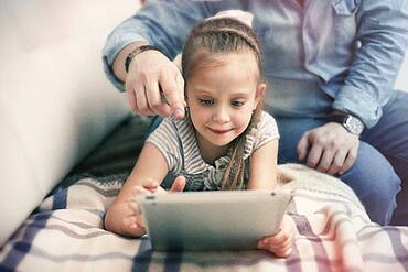 Caucasian father and daughter using digital tablet