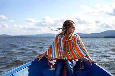 Caucasian teenage girl in canoe on lake