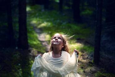 Caucasian girl playing in forest