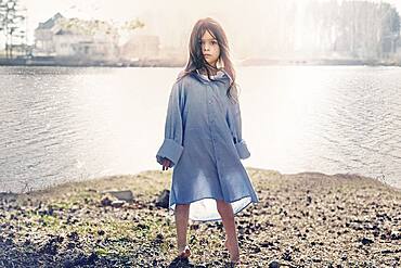 Caucasian girl standing at rural lake