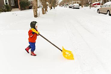 Caucasian boy shoveling snow