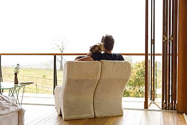 Caucasian couple lounging on balcony