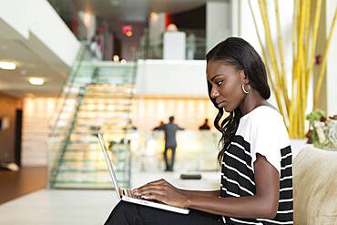 Businesswoman using laptop in hotel lobby