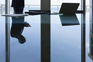 Hispanic businessman using cell phone in conference room