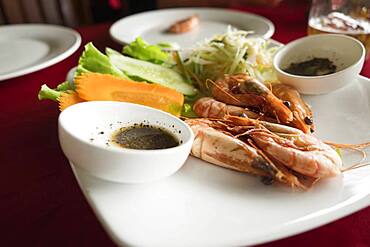 Plate of shrimp, carrot and salad on restaurant table