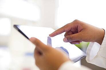 Mixed race scientist using digital tablet in laboratory