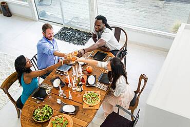 Friends toasting at dining room table