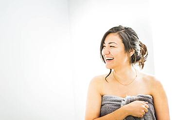 Laughing woman wrapped in towel