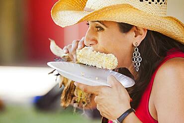 Close up of Hispanic woman eating corn