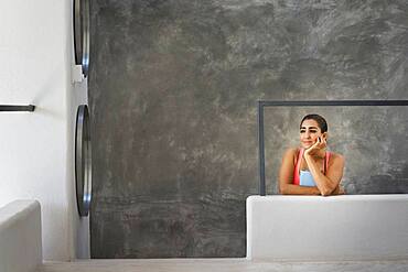 Hispanic woman sitting in modern living room