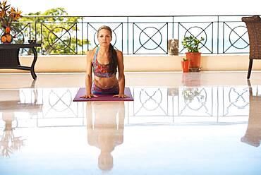 Hispanic woman practicing yoga on balcony