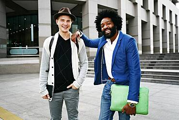 Businessmen smiling in courtyard