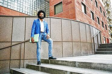 Mixed race businessman standing on steps