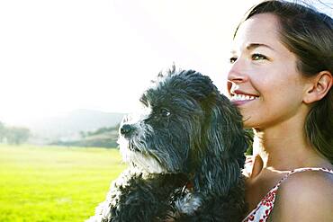 Caucasian woman holding dog outdoors