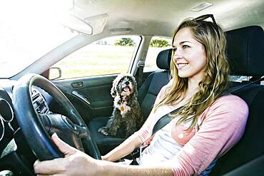 Caucasian woman driving with dog