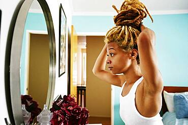 Black woman examining herself in mirror