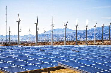 Wind turbines and solar panels in remote landscape