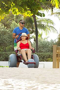 Man pushing paraplegic girlfriend in wheelchair