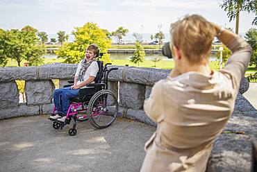 Mother photographing paraplegic daughter