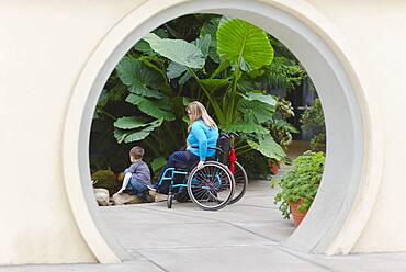 Paraplegic mother and son admiring plants