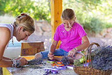 Caucasian mother and daughter making dried flower bundles