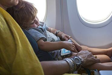 Caucasian mother holding baby son on airplane