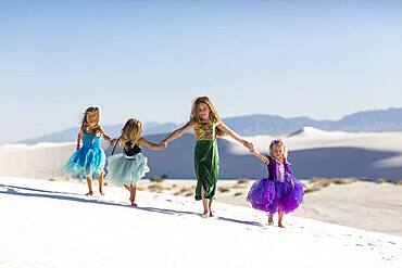 Girls walking on desert sand dunes