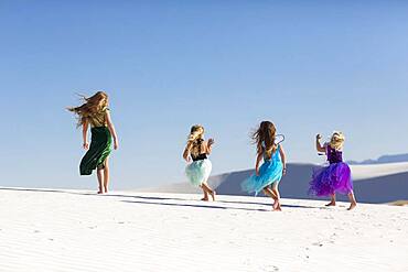 Girls walking on desert sand dunes