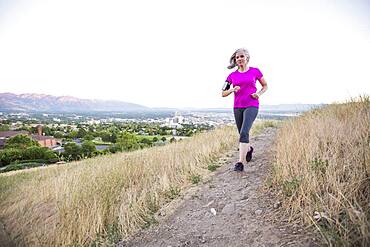 Caucasian woman running on hilltop