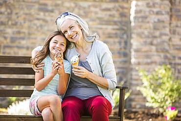 Caucasian grandmother and granddaughter eating ice cream