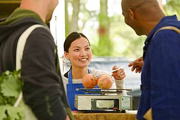 Clerk helping customers at farmers market