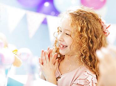 Close up of girl clapping at birthday party