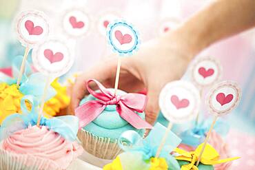 Close up of hand choosing cupcake at birthday party