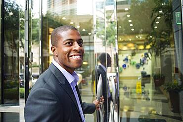 Black businessman opening office doors