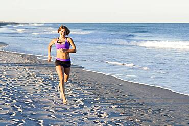 Caucasian woman jogging on beach